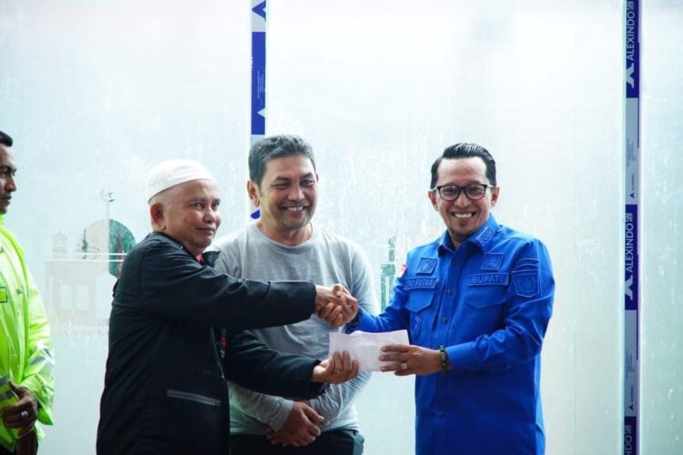 Hadiri Goro Mushalla, Eka Putra Serahkan Sumbangan 1 SUMBANGAN—Disaksikan Wali Nagari Padang Magek Syafril Jamal, Rosfairil menerima sumbangan dari Bupati Eka Putra.