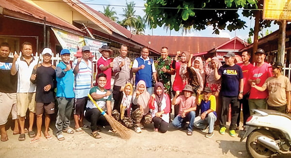 FOTO BERSAMA— Lurah Pisang, Deswarman, Ketua Pemuda Pisang Syamsul Rizal saat istirahat di depan SDN 04 Pisang bersama tokoh masyarakat, usai pelaksanaan ‘Padang Bagoro’, di sepanjang jalan utama Pisang, Minggu (28/1) pagi.