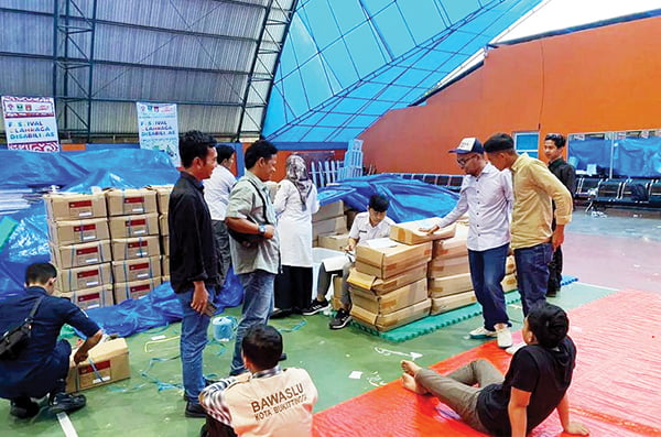 TINJAU— Komisioner KPU Bukittinggi meninjau proses penyortiran dan pelipatan surat suara Pemilu 2024 di GOR Bermawi Jalan By Pass, Kelurahan Kubu Gulai Bancah.