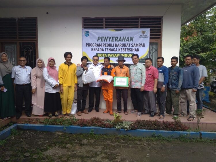 FOTO BERSAMA—Pj Wali Kota Payakumbuh Jasman dan Ketua Baznas berfoto bersama dengan perwakilan petugas kebersihan saat menyerahkan bantuan beras.