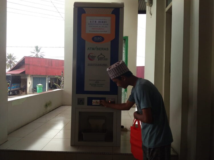 Masjid Baitul Islam Lampasi Sediakan ATM Beras 1 MASUKKAN ATM BERAS— Salah seorang pemilik ATM beras mengambil beras di Masjid Baitul Islam Kecamatan Lampasi, Kota Payakumbuh. Tinggal ditempelkan kartu ATM beras pada mesin yang disediakan, langsung keluar beras.