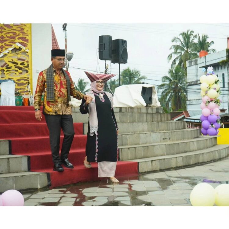 BAJU BASIBA—Ketua Dekranasda Solok Selatan, 
Ny Erniati Khairunas saat memegang tangan Bupati Khairunas menuruni tangga dalam even Solsel Basiba.