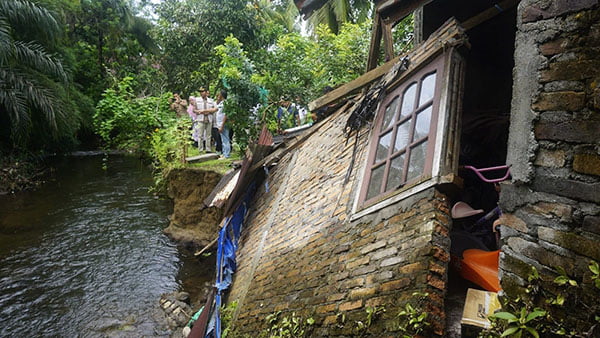 ROBOH TERSERET ARUS— Wabup Pasaman Barat Risnawanto tinjau lokasi rumah warga Ophir Blok B Kecamatan Luhak Nan Duo, yang terseret arus sungai Bakelok, kemarin.