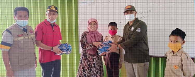 BAGIKAN MASKER— Kalaksa BPBD Kesbangpol, I Putu Venda, S.STP, M.Si dan Kepala Dinas Pendidikan dan Kebudayaan  (Disdikbud), Nasrulmembagikan masker pada pelajar di sekolah-sekolah untuk mengantisipasi efek erupsi Gunung Marapi.