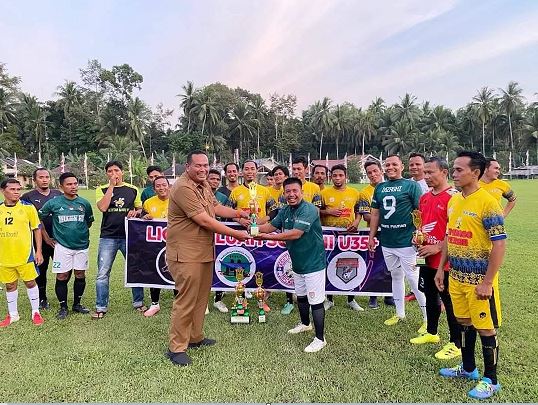 SERAHKAN PIALA— Sekda Kota Pariaman Yota Balad saat menyerahkan piala kepada pemenang Piala Liga Paluah Sore U 35+.