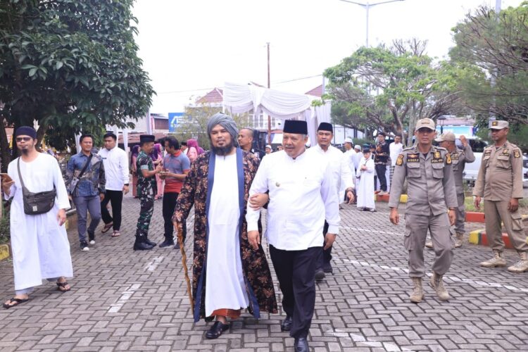 HADIRI TABLIGH AKBAR— Wali Kota Solok, Zul Elfian Umar berjalan memasuki arena tabligh akbar bersama Ustaz Derry Sulaiman.