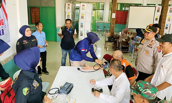 PEMERIKSAAN KESEHATAN GRATIS— Personel Biddokkes Polda Sumbar melakukan pemeriksaan gratis kepada anggota PPK, yang akan bertugas untuk melakukan penghitungan suara di tingkat kecamatan, Jumat (16/2), di Kecamatan Padang Barat dan Padang Selatan.