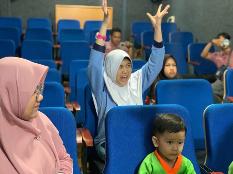 ANTUSIAS—Terlihat seorang penonton dari murid SLB sangat antusias menyaksikan rekannya ikut dalam perlombaan dengan spontan angkat tangan penuh kegembiraan.
