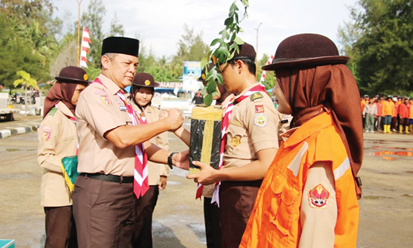 PERKEMAHAN SABTU-MINGGU— Danrem 032/Wirabraja Brigjen TNI Rayen Obersyl, memberikan bibit pohon kepada pada anggota Pramuka, saat pembukaan Perkemahan Sabtu-Minggu (Persami) Pramuka Saka Wira Kartika, di Pantai Air Manis Kota Padang, Sabtu (3/2).
