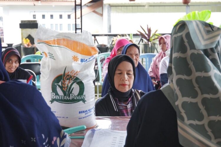 PENERIMA BANTUAN— Para warga  di Kelurahan Kampung Manggis, Kecamatan Padang Panjang Barat antrean untuk mendapat bantuan beras.