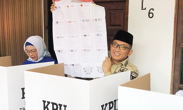 Wako Gandeng Istri dan Mertua, Wawako Datangi TPS 10, ”Semoga Dapat Pemimpin dan Wakil Rakyat Amanah” 1 PERLIHATKAN SURAT SUARA— Wako Padang Hendri Septa, memperlihatkan surat suara saat akan menggunakan hak pilihnya di TPS 08 Ulak Karang Utara, Rabu (14/2) pagi. Wako datang bersama istri dan mertuanya.