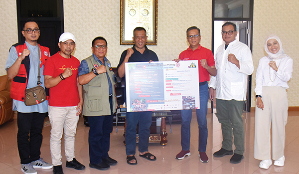 SERAHKAN BANTUAN— Dirut PT Semen Padang Indrieffouny Indra, mengunjungi Posko Darurat Bencana yang berada di Kantor Camat Koto XI Tarusan, Sabtu (16/3), serta menyerahkan bantuan secara simbolis senilai Rp 259.440.000 kepada Bupati Rusma Yul Anwar, di rumah dinas bupati.