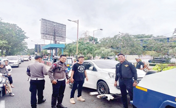 TIMBULKAN KEMACETAN— Kendaraan roda empat yang parkir di badan jalan, di depan Basko Grand Mall, menyebabkan ruas jalan utama di Kota Padang ini macet pada akhir pekan, kemarin. Dishub menderek 5 unit mobil dan dibawa ke kantor Unit Laka Satlantas Polresta, karena kendaraan-kendaraan tersebut telah menyebabkan penyempitan badan jalan dan berakibat kemacetan panjang.
