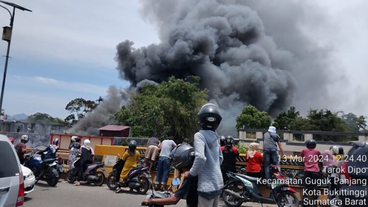 KEBAKARAN—Warga menyaksikan kebakaran tujuh rumah dan satu gudang dari Fly Over Pasar Aur Bukittinggi.