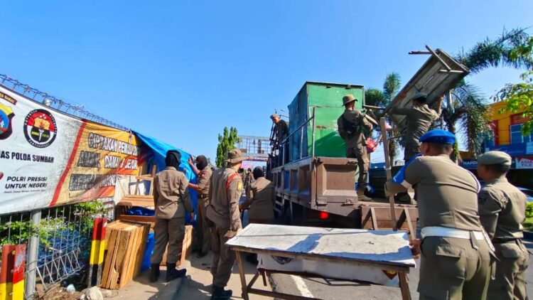 PENERTIBAN PKL— Sejumlah barang dagangan milik PKL yang masih diletakkan di atas fasum di kawasan Stasiun KA Tabing, diangkut petugas Satpol PP dan dibawa ke Mako, di Jalan Tan Malaka, Rabu (20/3).