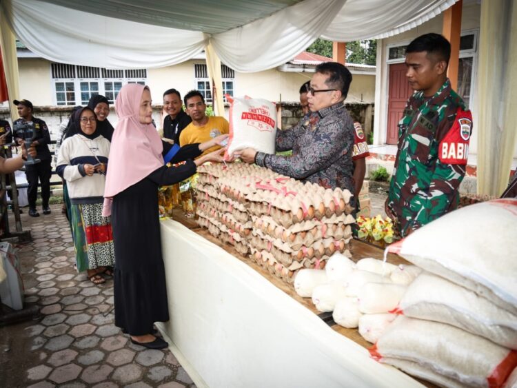 Harga Sembako Meroket, Pemko Gelar Pasar Murah 1 DISERBU— Pj Wako Payakumbuh Jasman, ikut melayani warga yang membeli sembako murah, di pelataran parkir kantor Dinas Koperasi dan UKM, kemarin.