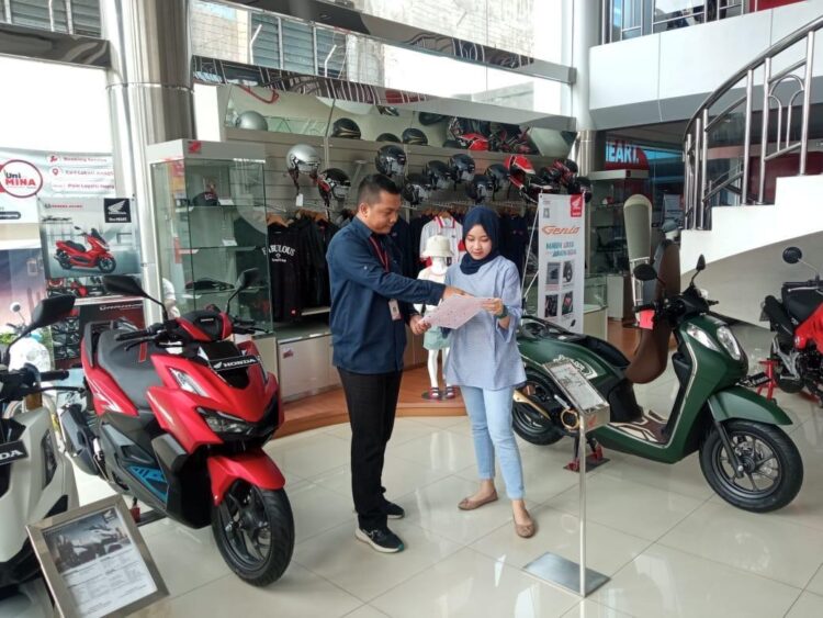 LAYANI KONUSMEN-Sales marketing PT Menara Agung melayani konsumen yang melakukan pembelian sepeda motor Honda.