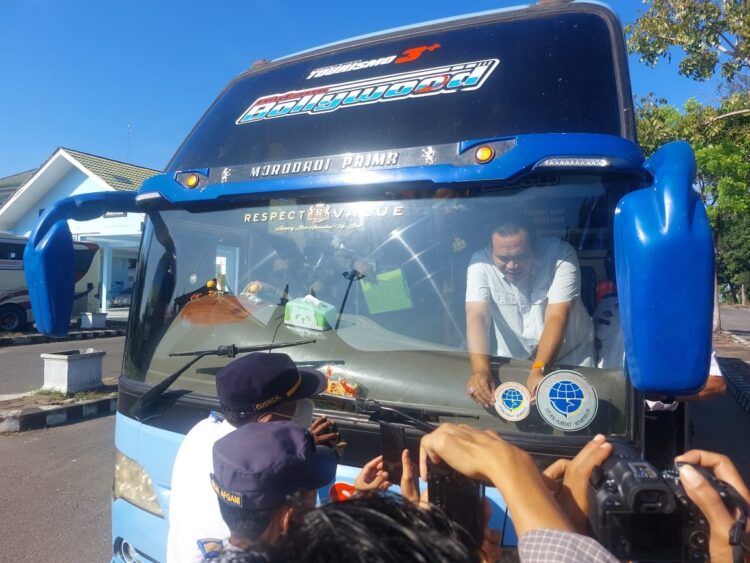 PASANGKAN STIKER— Sekda Kota Pariaman, Yota Balad melakukan pemasangan stiker bagi bus yang dinyatakan laik jalan setelah melalui ramp check yang dilakukan Petugas Terminal Tipe A Jati Pariaman yang berada di bawah kewenangan BPTD Wilayah II Sumbar, Rabu (20/3).