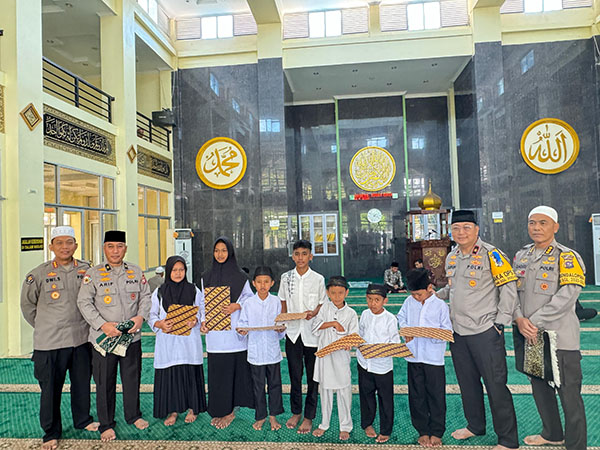 SANTUNAN—Wakapolda Sumbar Brigjen Pol Gupuh Setiyono didampingi pejabat utama Polda Sumbar menyerahkan santunan kepada anak yatim.