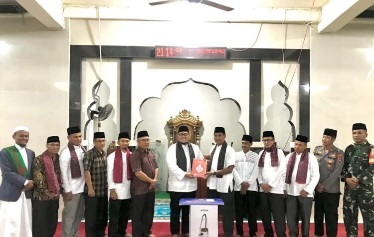 SERAHKAN BANTUAN— Wabup Richi Aprian selaku ketua TSR Pemkab Tanahdatar menyerrahkan bantuan untuk pembangunan masjid Assadah Koto Panjang, Selasa (19/3).