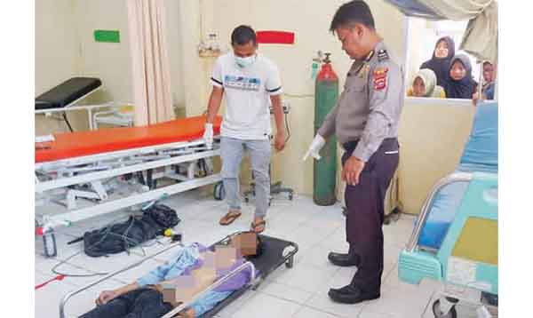 GANTUNG DIRI— Korban Bambang Hendri Syaputra (44) yang ditemukan tewas tergantung di pohon dekat Danau Maninjau, dievakuasi ke Pukesmas.