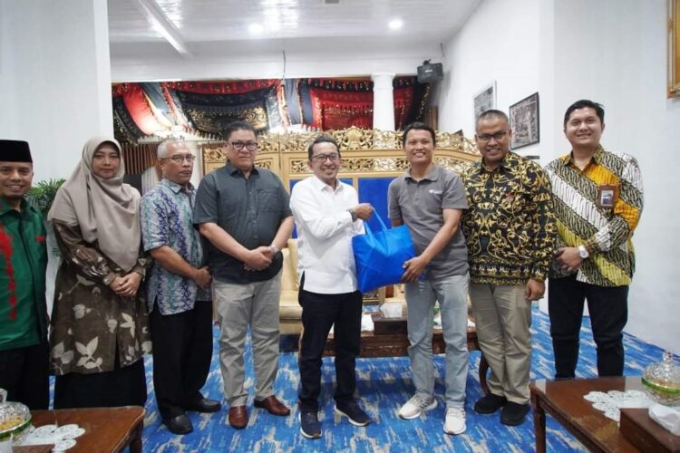 SERAHKAN—Direktur Infrastruktur Ekosistem Syariah Komite Nasional Ekonomi dan Keuangan Syariah (KNEKS) Sumbar Dr. Sutan Emir Hidayat serahkan pada Bupati Eka Putra SE MM pada Kamis (19/4) malam di gedung Indojolito Batusangkar.