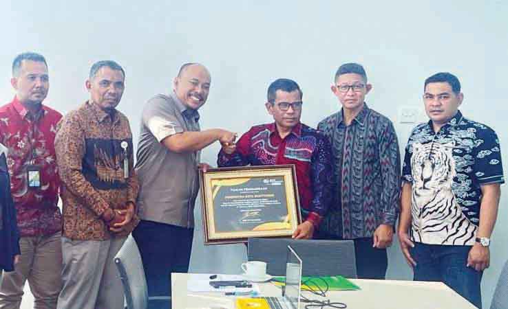 RAIH PENGHARGAAN— Sekdako Bukittinggi, Martias Wanto menerima penghargaan yang diraih oleh Bukittinggi diserahkan oleh Kepala Kantor BPJS ketenagakerjaan Wilayah Kanwil Sumbar, Riau dan Kepri, Eko Yuyulianda di Bukittinggi, Rabu (24/4).