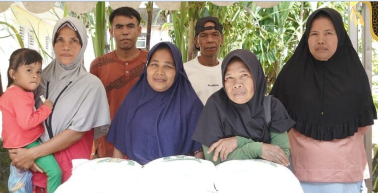 BERAS PEMBAGIAN— Dasni (42 tahun) saat menjemput beras Bantuan Pangan Cadangan Beras Pemerintah (BP-CBP) bagiannya.