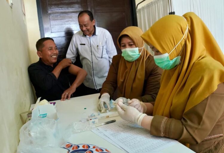 JALANI—Terlihat seorang Calon Jamaah Haji (CJH) Kota Padang Panjang menjalani vaksinasi meningitis yang difasilitasi Dinas Kesehatan (Dinkes), Senin (22/4), di Puskemas Gunung.
