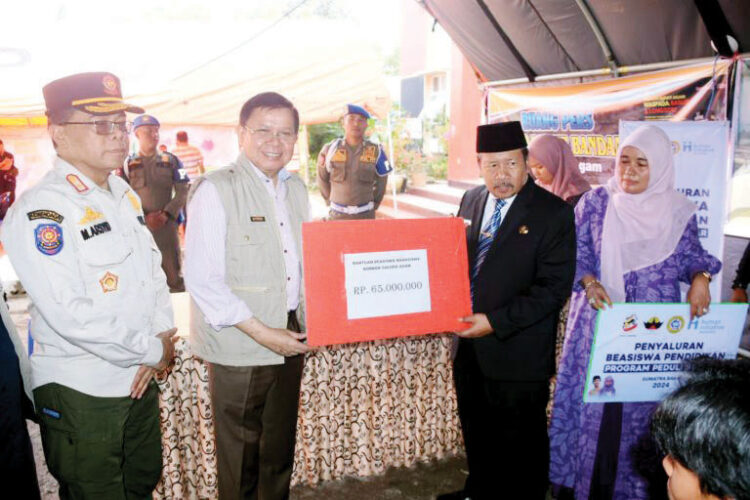 SALURKAN BANTUAN— Presiden Direktur Minang Diaspora, Prof Fasli Jalal salurkan beasiswa pendidikan bagi korban bencana alam banjir bandang dan lahar dingin di Kabupaten Agam, di Posko Utama Bencana Alam Kantor Camat Sungai Pua, Rabu, (29/5).