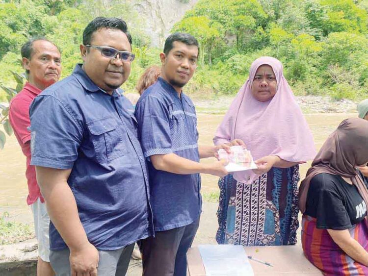 SERAHKAN BANTUAN— Ketua Baznas Kota Bukittinggi, Edi Syamian menyerahkan bantuan kepada warga terdampak banjir bah di Ngarai Sianok.
