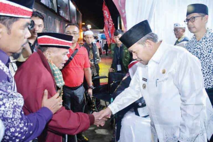 SAMBUT CJH— Bupati Agam Andri Warman menyambut 386 CJH asal Agam yang baru turun dari armada bus saat baru tiba di Asrama Haji Embarkasi Padang, Minggu (12/5) malam.