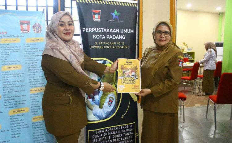 LOMBA HUT PADANG— Kadis Perpustakaan dan Kearsipan Kota Padang, Feri Mulyani bersama Kasi Promosi dan Layanan Perpustakaan, Sefni Hayati saat menunjukkan poster lomba video pendek untuk memeriahkan HUT Kota Padang.