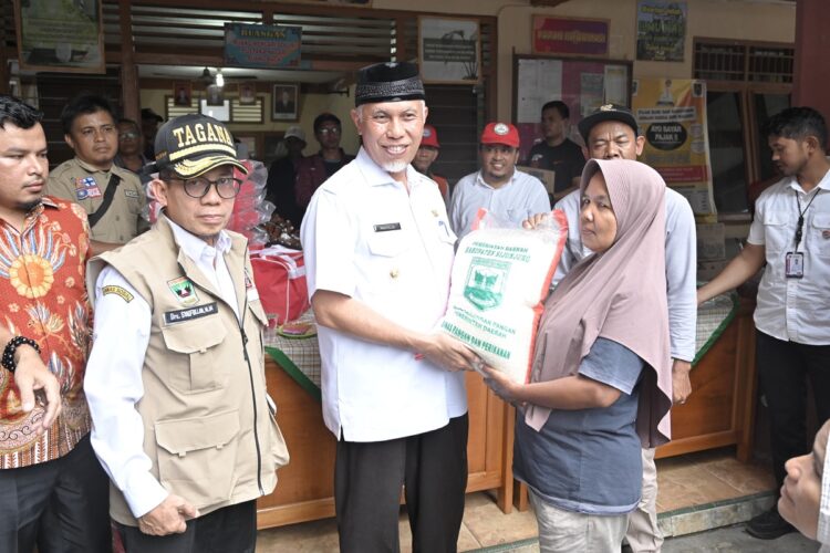 BANTUAN KORBAN BENCANA— Gubernur Sumbar Mahyeldi Ansharullah, menyerahkan bantuan uang dan beras kepada korban, saat melakukan peninjauan lokasi dampak bencana banjir dan longsor.
