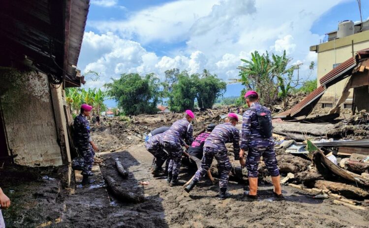 BERJIBAKU—Terlihat Tim Gulben Lantamal II berasal dari Yonmarhanlan II sedang berjibaku bersama masyarakat bersihkan puing puing di Cingkariang, Kecematan Banu Hampu, Kabupaten Agam.