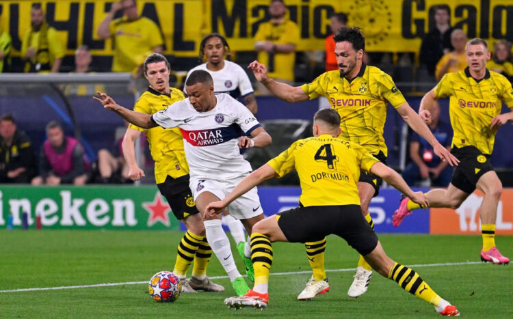 LEWATI HADANGAN— Pemain PSG Kylian Mbappe berusaha melawati hadangan pemain Borussia Dortmund saat kedua tim bersua pada leg 1 Semifinal UCL 2023/2024, Kamis (2/5) yang lalu di Stadion Signal Iduna Park. Pada laga tersebut, Dortmund menangdengan skor tipis 1-0.