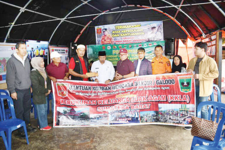 BANTUAN PERANTAU— Bupati Agam Andri Warman saat menrima bantuan dari perantau di Posko Utama bencana banjir bandang dan lahar dingin di Bukik Batabuah, Kamis (23/5).