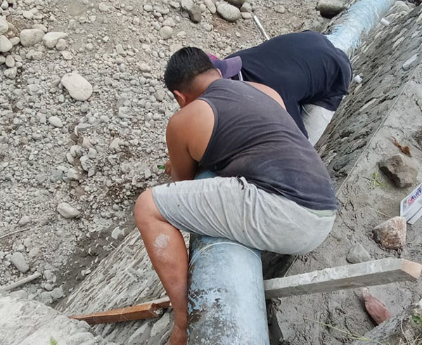 PEMERIKSAAN— Dua orang tenaga operator Perusda Air  Tirta Anai melakukan pemeriksaan pipa.