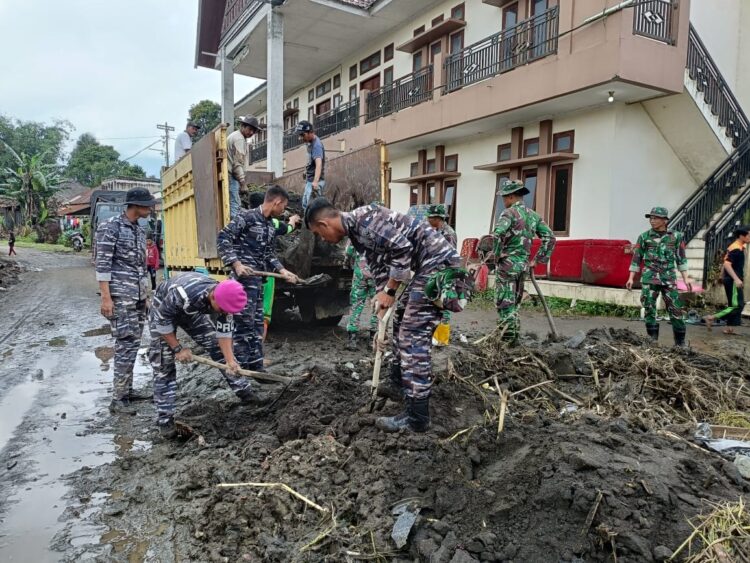 BERSIHKAN MATERIAL BANJIR BANDANG— Tim Satgas Gulbencal Pangkalan Utama TNI AL Lantamal II Padang, turun ke lokasi bencana berishkan material banjir bandang.