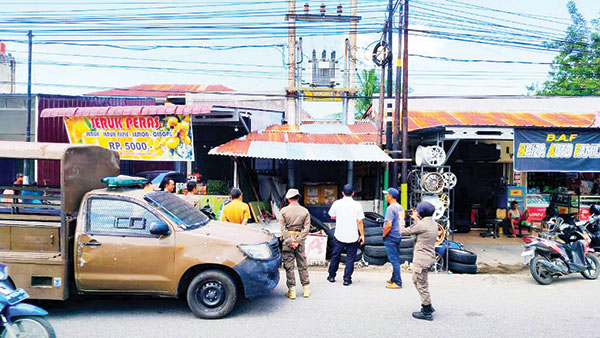 PERINTAH PEMBONGKARAN—  Petugas Satpol PP mendatangi pemilik bangunan semi permanen yang berdiri berdekatan dengan trafo listrik PLN bertegangan tinggi di jalan Dr. Sutomo, Kecamatan Padang Timur, Selasa (28/5).