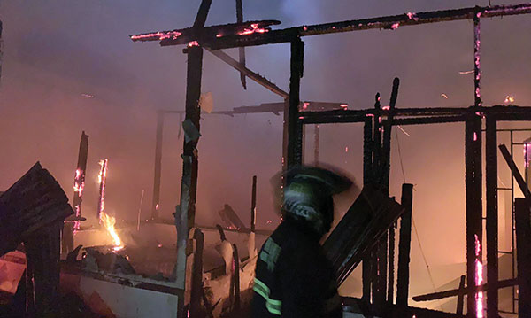 KEBAKARAN— Petugas Damkar melakukan penyemprotan air untuk memadamkan api yang membakar rumah dan 
ruko di Jalan Durian Ratus, Kelurahan Kurao Pagang , Kecamatan Nanggalo.