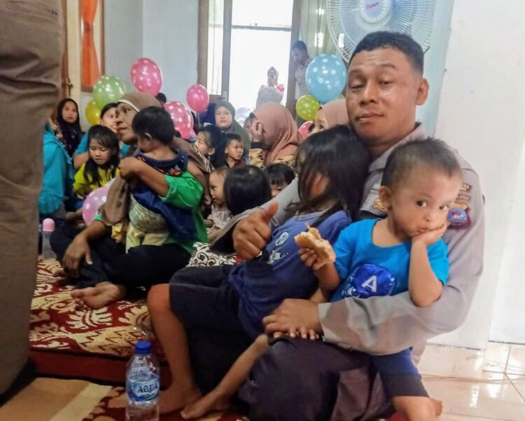 GENDONG BALITA— Aipda Dian Wihendro Ratno, bapak stunting Kota Padang saat menggendong dua orang balita pada acara kemarin.