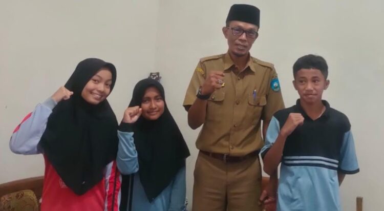 FOTO BERSAMA— Kepala SMPN 8 Sawahlunto Alfisani bersama tiga orang siswanya yang berhasil lolos OS tingkat Kota Sawahlunto.