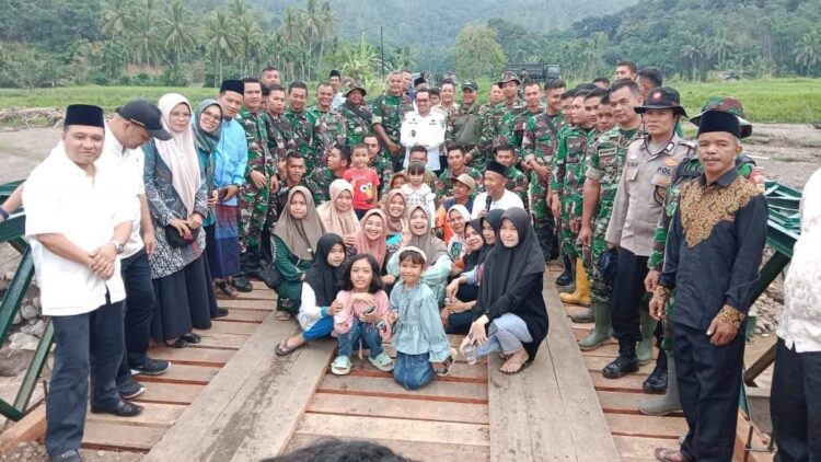 FOTO BERSAMA—Warga Kompleks BBR  foto bersama dengan Bupati Tanahdatar Eka Putr dan anggota TNI, di jembatan bailey yang sudah tuntas dibangun dan bisa dilalui warga.
