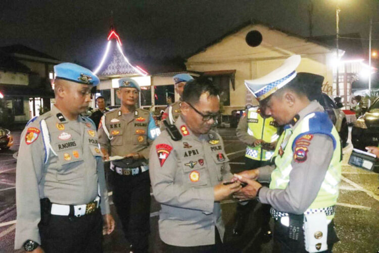 Sanksi Tegas! Polresta Bukittinggi Peringatkan Anggota yang Main Judi Online 1 Periksa telepon— Wakapolresta Bukittinggi AKBP Apri Wibowo memeriksa telepon genggam milik personel kepolisian untuk memastikan petugas tidak terlibat dalam praktik judi online, Minggu (16/6) malam.