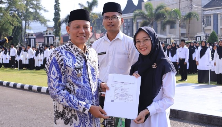 SERAHKAN SK— Bupati Pasaman Sabar AS menyerahkan SK P3K kepada salah seorang guru di Pasaman.