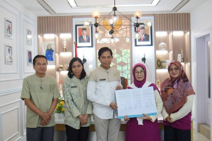 LIHATKAN—Sekda Kota Sawahlunto Ambun Kadri lihatkan tandatangan kerjasama usai kesepakatan.