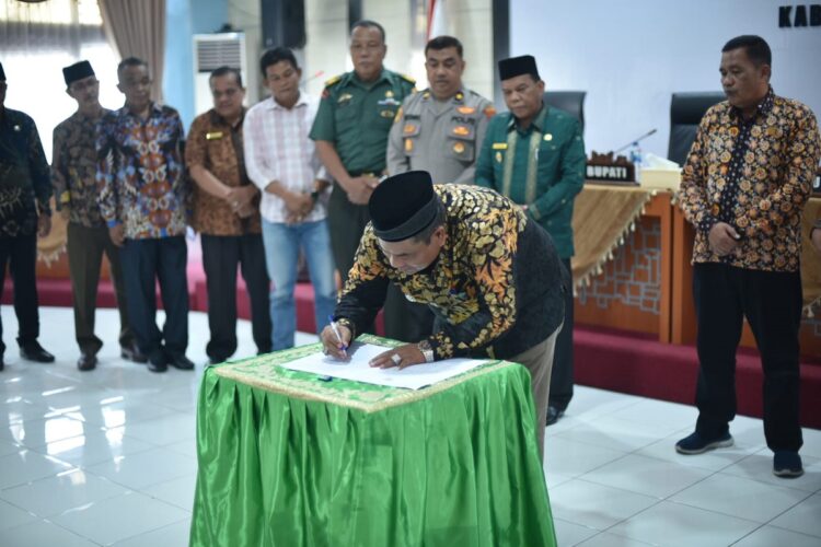 TEKEN RANPERDA—Bupati Padangpariaman Suhatri Bur saat menandatangani Ranperda Rencana Pembangunan Jangka Panjang Daerah (RPJPD) dalam mewujudkan Kabupaten Padangpariaman Emas dan Indonesia Emas menjadi perda.