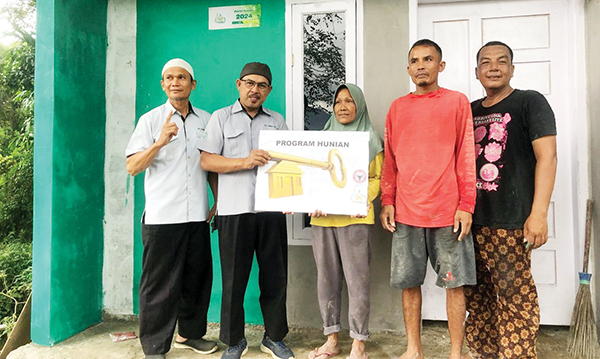 SERAHKAN KUNCI RUMAH— Kepala Pelaksana Harian UPZ Baznas PT Semen Padang Muhammad Arif dan Kepala Pelaksana Teknis UPZ Baznas PT Semen Padang Mafril, menyerahkan kunci rumah bantuan yang telah selesai dibangun kepada Silvia Dewina.