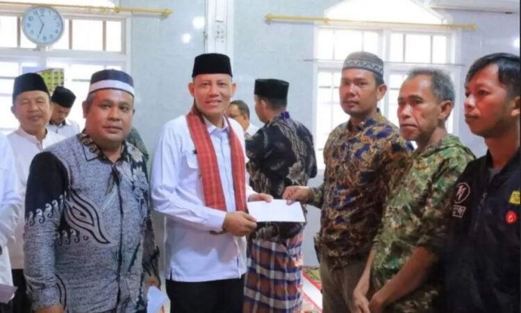 SERAHKAN BANTUAN— Bupati Sabar AS menyerahkan bantuan saat kegiatan Safari Subuh Pemkab Pasaman di Masjid Nurul Huda Tunas Harapan, Jorong III Rambah, Nagari Lansek Kodok, Kecamatan Rao Selatan.